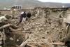 Residents walk through the remains of a collapsed building in Eastern Turkey