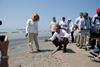 President Barack Obama and Lafourche Parish President Charlotte Randolf, left, inspect a tar ball as they look at the effect the BP oil spill is having on Fourchon Beach in Port Fourchon, La., May 28, 2010