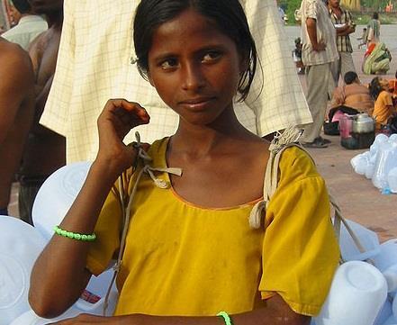 A girl selling plastic containers for carrying Ganges water