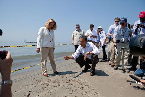 President Barack Obama and Lafourche Parish President Charlotte Randolf, left, inspect a tar ball as they look at the effect the BP oil spill is having on Fourchon Beach in Port Fourchon, La., May 28, 2010